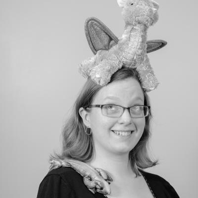 Photo of Sophia M. with a stuffed dragon on her head