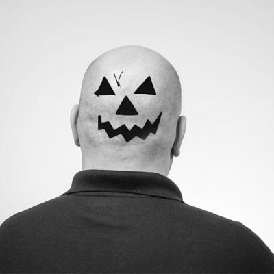 Tom F. facing away from the camera with a jack o'lantern face on the back of his head