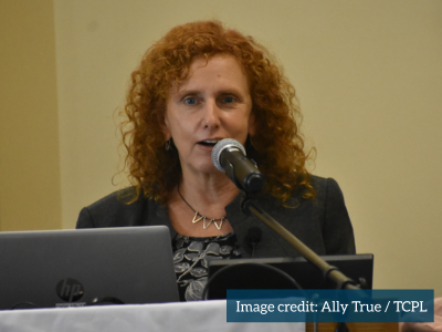 Author Maia Szalavitz speaks into a microphone as part of a book talk and q&a at TCPL on April 19, 2025
