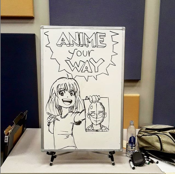 Photo of a dry erase board featuring a drawing of a person holding a drawing of a person