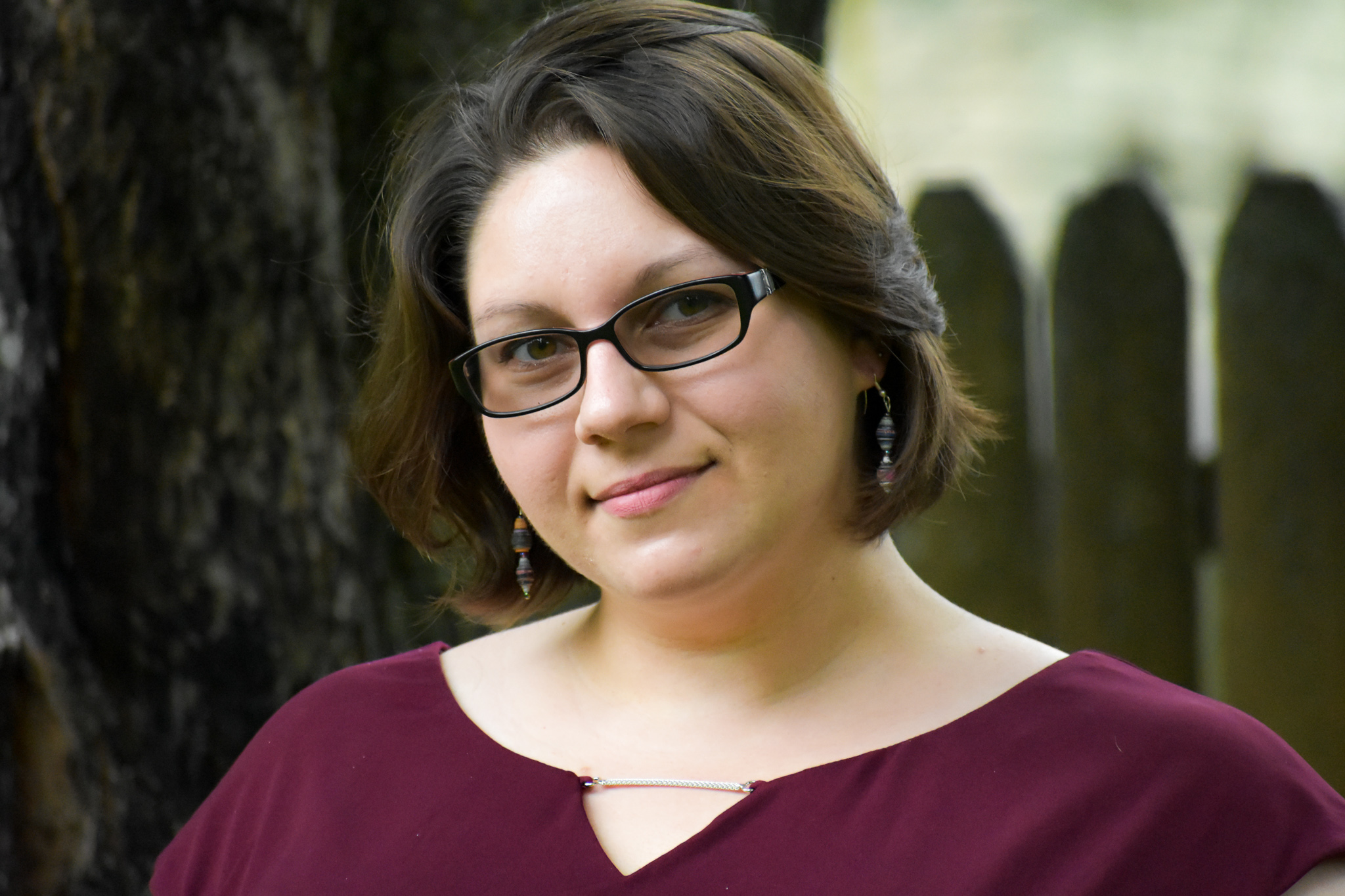 Headshot of the author, a woman with chin length brown hair and glasses, wearing a burgundy shirt.