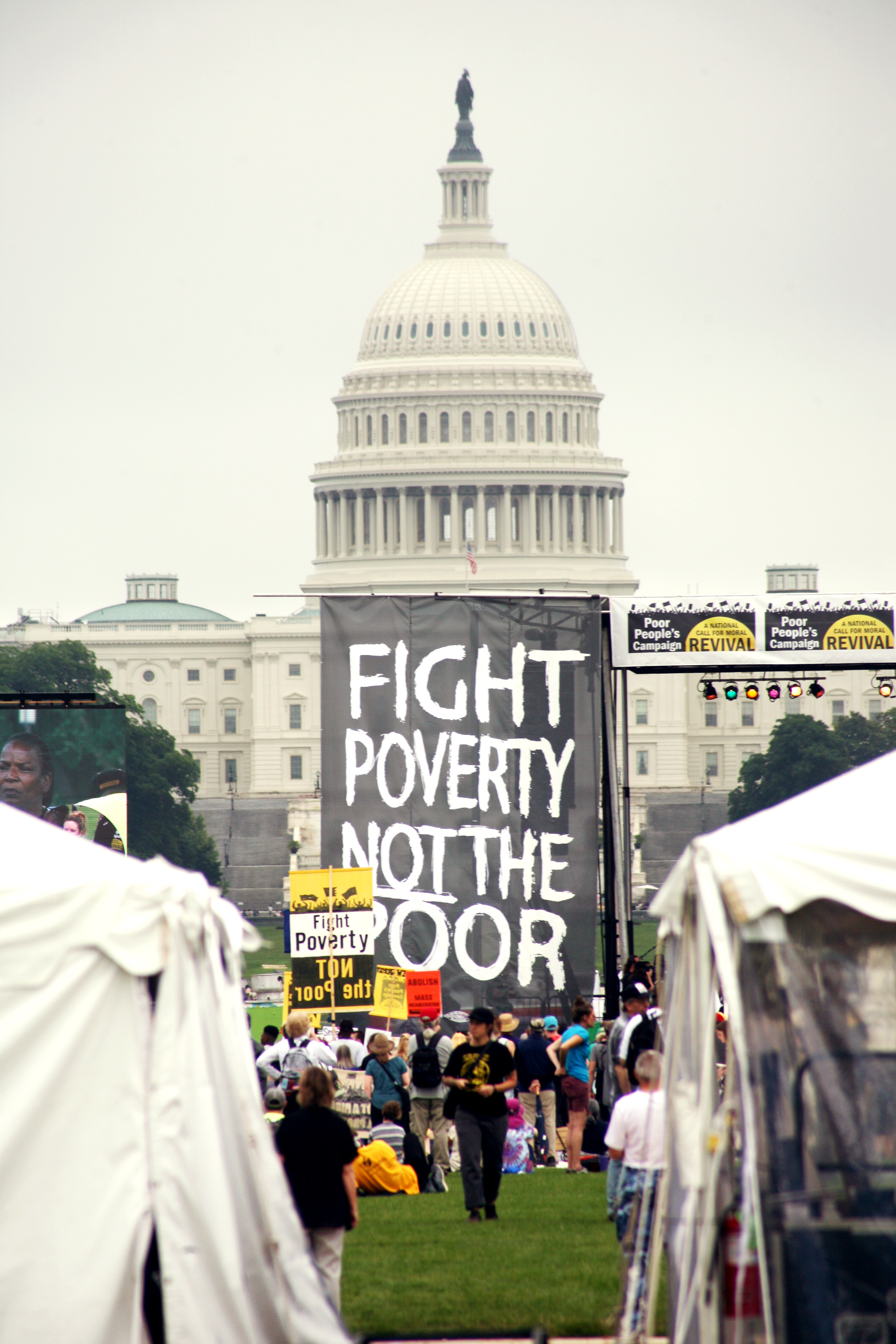 Image from Poor People's Campaign in 2018 of a sign in front of the capitol that reads "Fight Poverty Not the Poor"