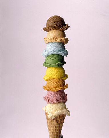 An ice cream cone stacked with eight different flavors in multiple colors