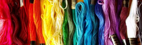 A photograph of embroidery floss in rainbow colored order.