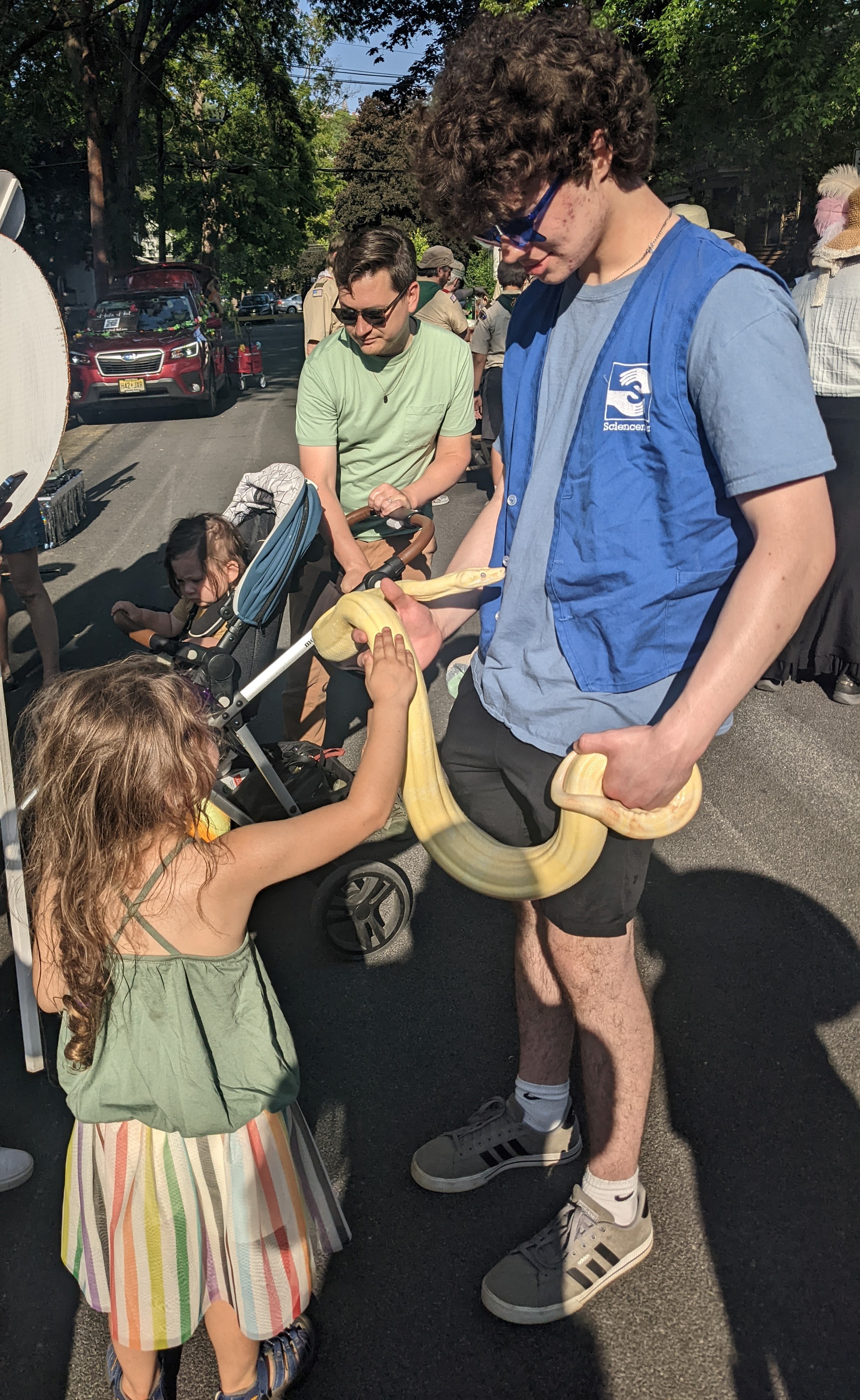 Photograph of a small child meeting a snake handled by a Sciencenter staff member