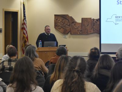 Emerson DeMeester-Lane addressing an audience in the BorgWarner Community Room