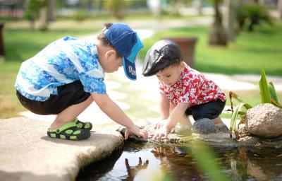 Two babies playing in a pond