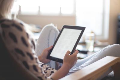 Canva- Woman sitting on chair using black ipad