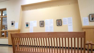 An image along the Avenue of the Friends with a bench in the foreground, and the portraits and stories that accompany them in the background