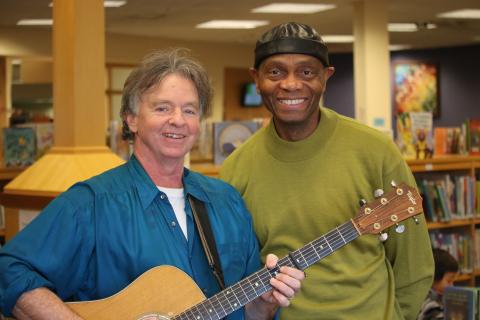 John Simon, holding a guitar, and Cal Walker in TCPL's Youth Services department