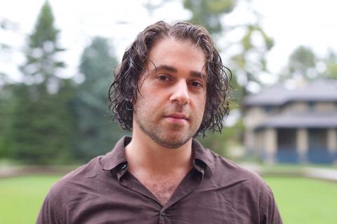 Photo of man with medium length brown hair wearing polo shirt