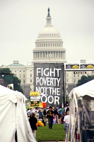 Image from Poor People's Campaign in 2018 of a sign in front of the capitol that reads "Fight Poverty Not the Poor"