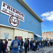 An image of people lined up outside the Friends of the Library warehouse for one of its semiannual book sales.