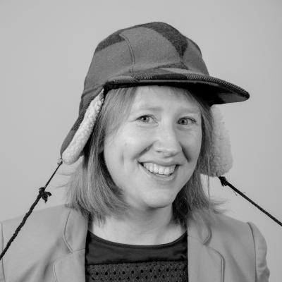 Photo of Alice B smiling at the camera wearing a hunter's cap