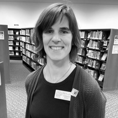 A black and white picture of Kat Savage in the Youth Services section of the library